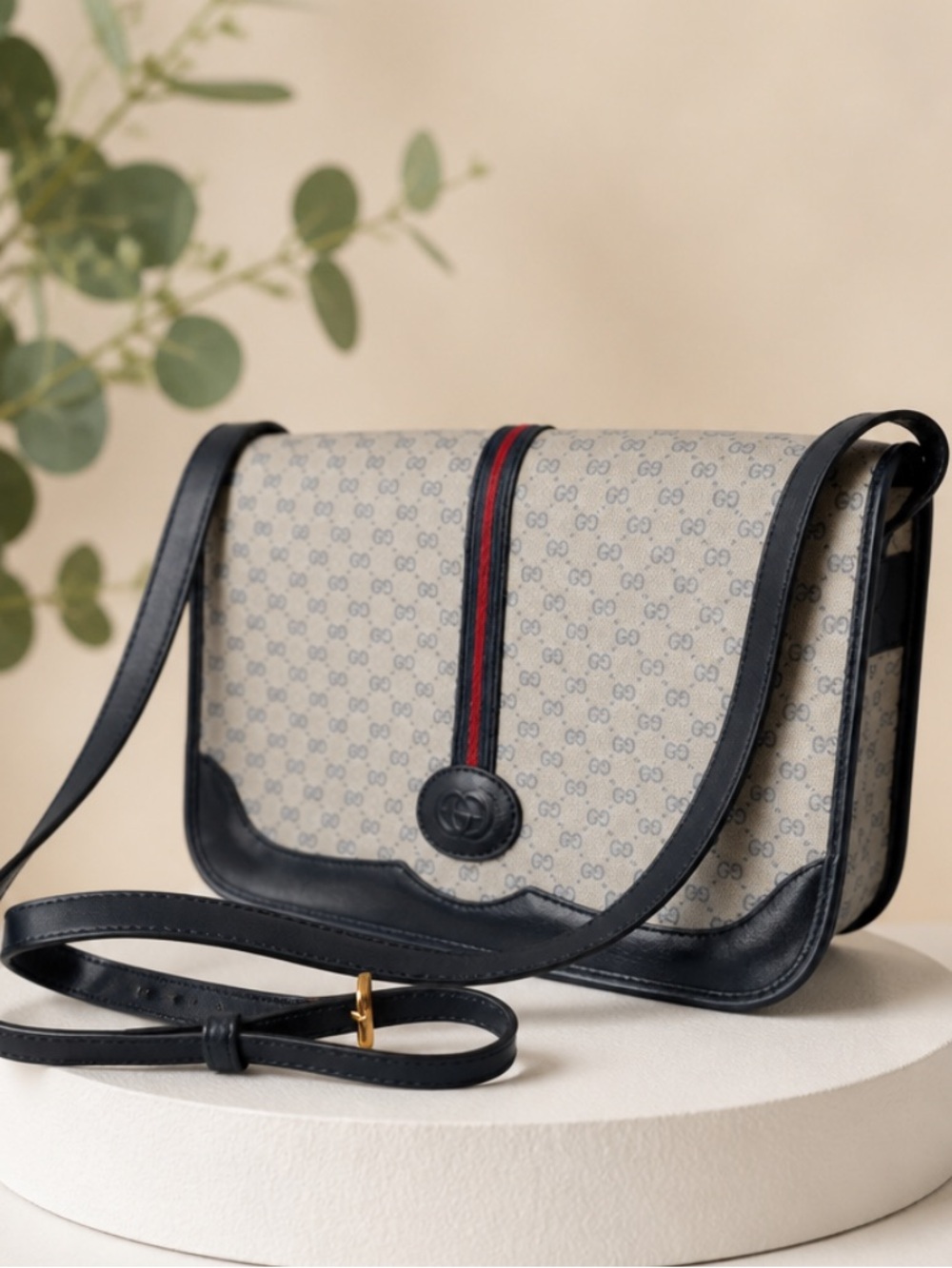 Gucci Grey GG Supreme crossbody with Black trim and red-blue stripe.